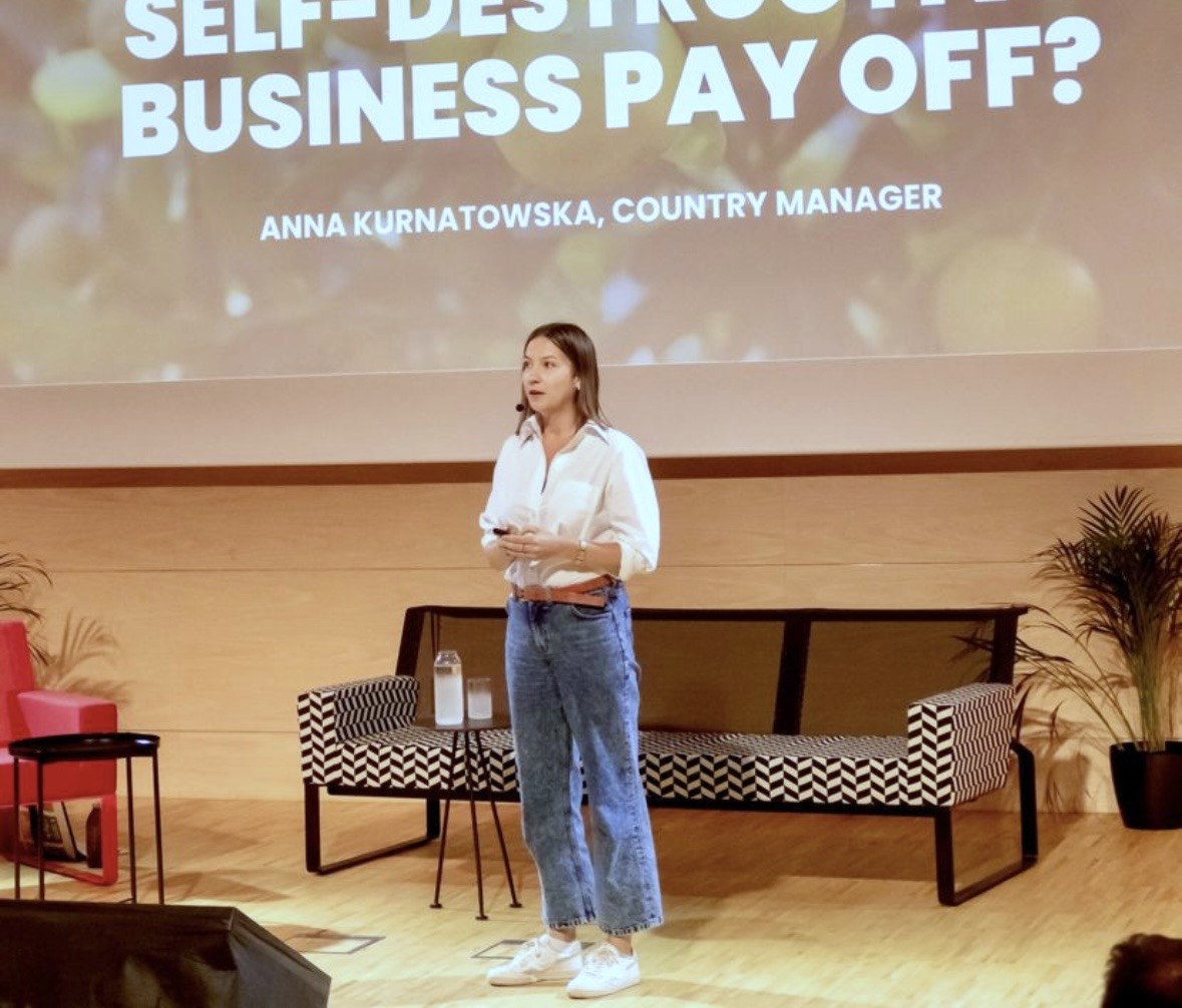 Anna Kurnatowska podczas wystąpienia na konferencji, na ekranie za nią tytuł jej prezentacji